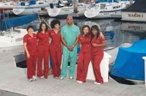 Dr. Sanusi Umar and the DermHair clinic staff pose for a group picture in front of the clinic.